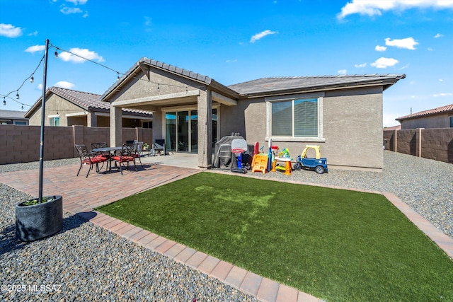 back of property with a patio area, a fenced backyard, a yard, and stucco siding