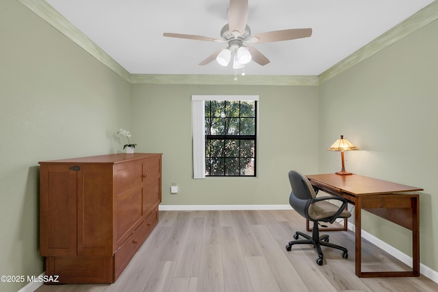 home office with light wood-type flooring, a ceiling fan, baseboards, and crown molding