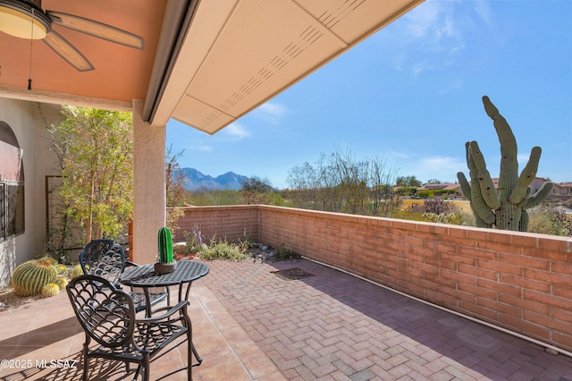 view of patio / terrace featuring a mountain view, fence, and a ceiling fan