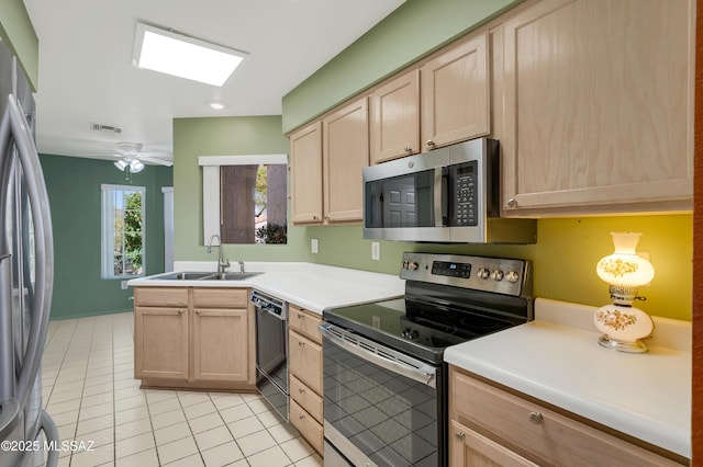 kitchen with visible vents, stainless steel appliances, a sink, and light brown cabinetry