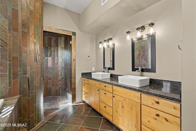 full bath featuring a sink, a shower stall, and double vanity