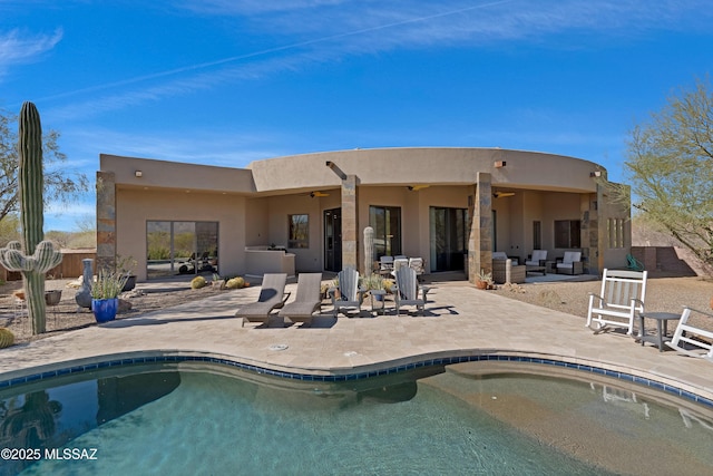 rear view of property with ceiling fan, outdoor lounge area, a patio area, and an outdoor pool