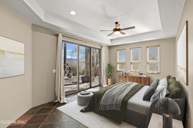 bedroom featuring stone tile floors, a raised ceiling, a ceiling fan, access to outside, and recessed lighting