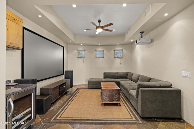 cinema room featuring beverage cooler, visible vents, ceiling fan, stone tile flooring, and recessed lighting