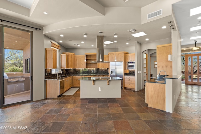 kitchen with stainless steel appliances, stone tile flooring, visible vents, and a sink