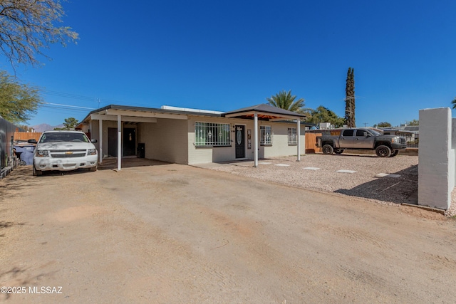 view of front of property featuring driveway and fence