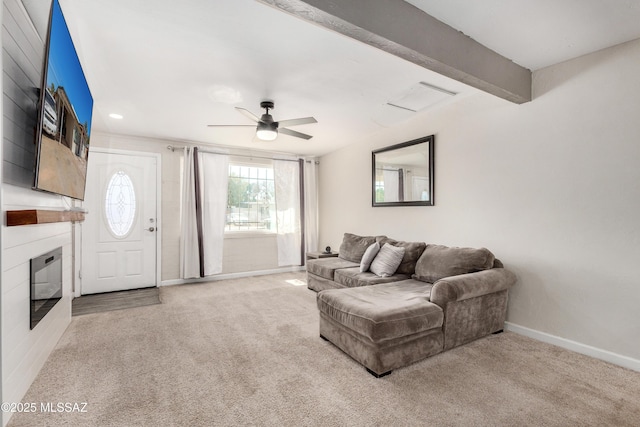 living room featuring a large fireplace, baseboards, a ceiling fan, beamed ceiling, and carpet