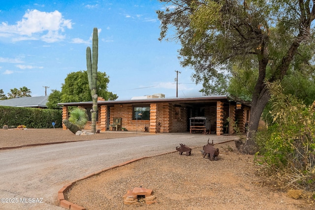 log home with a carport, driveway, and log exterior