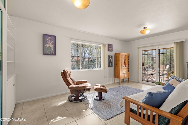 sitting room with tile patterned floors, baseboards, and a healthy amount of sunlight