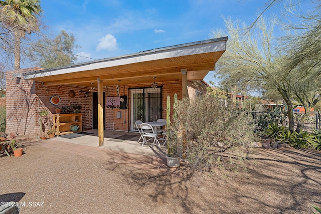 back of property featuring a patio, fence, and brick siding