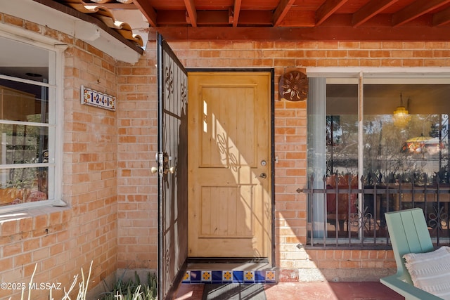 doorway to property featuring brick siding