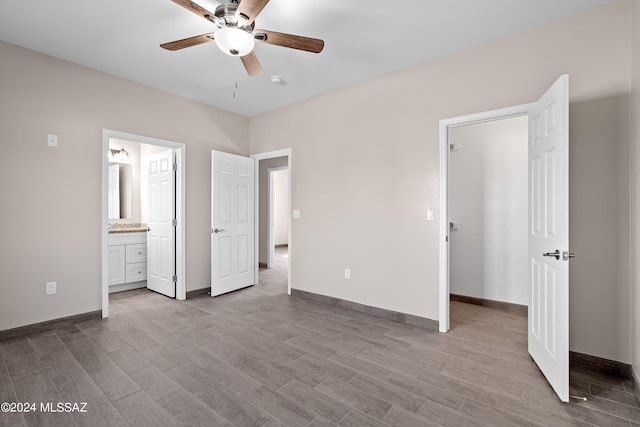 unfurnished bedroom with ceiling fan, connected bathroom, baseboards, and wood finished floors