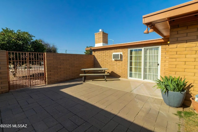 view of patio featuring an AC wall unit and fence