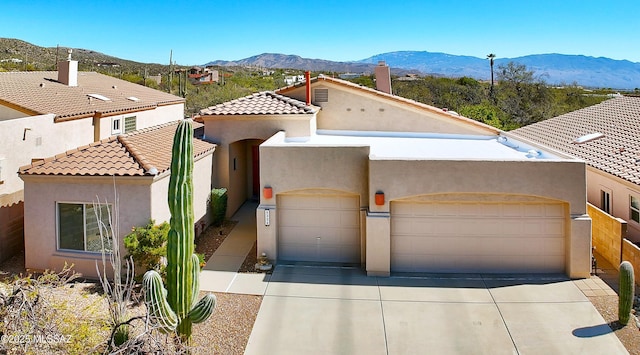 view of front facade featuring a garage, driveway, a mountain view, and stucco siding