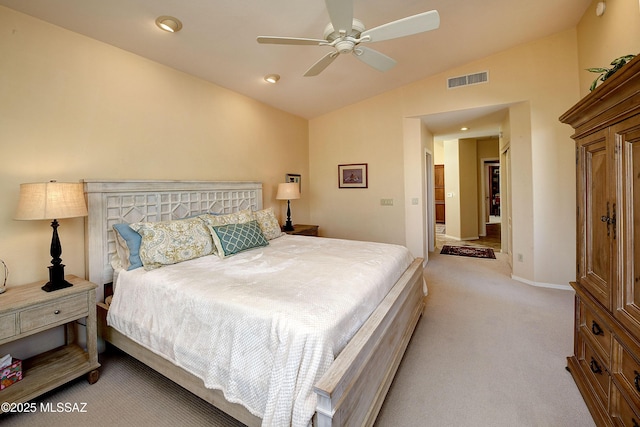 bedroom featuring lofted ceiling, light colored carpet, visible vents, a ceiling fan, and baseboards