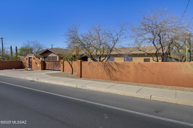 view of front of property featuring a fenced front yard, stucco siding, and concrete driveway