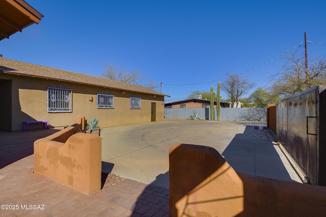 exterior space with stucco siding, a patio, and a fenced backyard