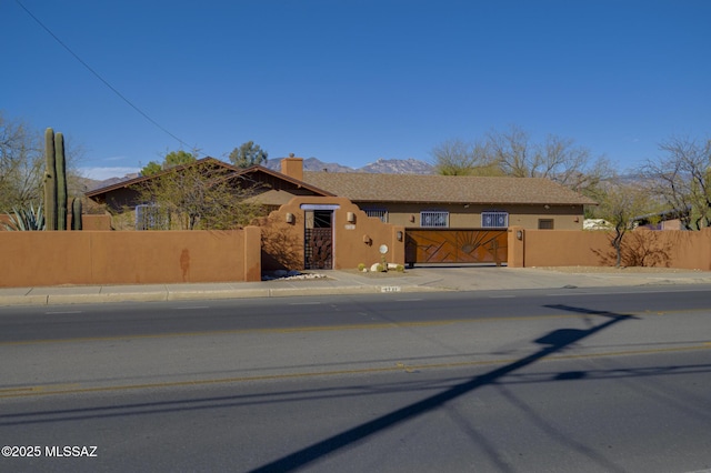 view of front of home featuring a gate, a fenced front yard, and stucco siding