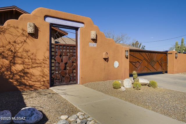 exterior space featuring stucco siding and a gate