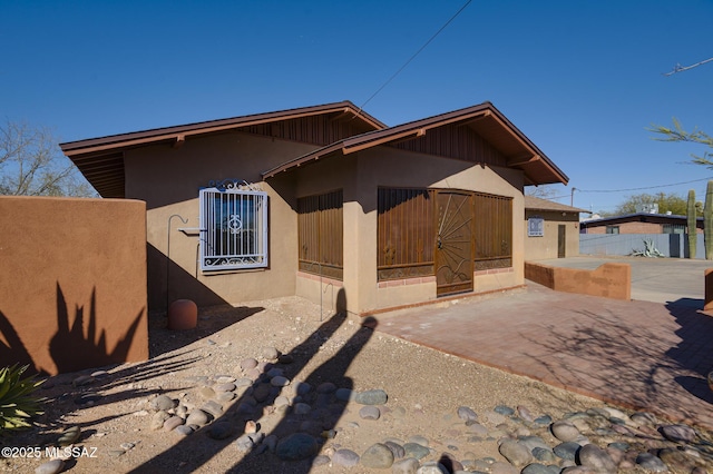 view of front of house with a patio and stucco siding