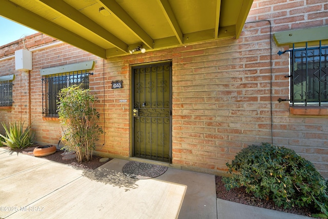 doorway to property featuring brick siding