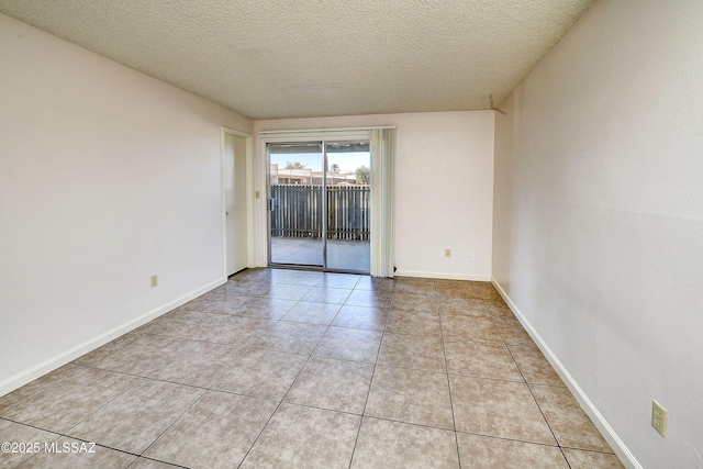 35 E Pastime Rd, Tucson, AZ 85705 - spare room with baseboards, a textured ceiling, and light tile patterned flooring