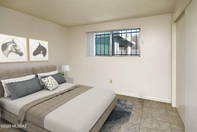 35 E Pastime Rd, Tucson, AZ 85705 - tiled bedroom featuring a textured ceiling and baseboards