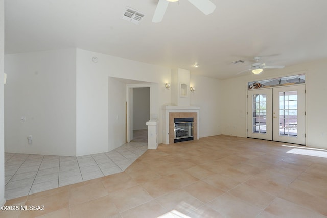 unfurnished living room with light tile patterned floors, visible vents, a ceiling fan, and french doors