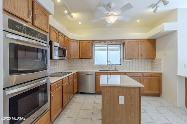 kitchen featuring stainless steel appliances, tasteful backsplash, a sink, and light tile patterned floors