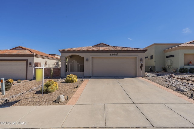 mediterranean / spanish-style house featuring a garage, fence, concrete driveway, a gate, and stucco siding