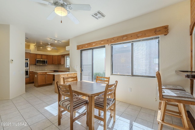 dining room featuring ceiling fan, visible vents, a wealth of natural light, and light tile patterned flooring