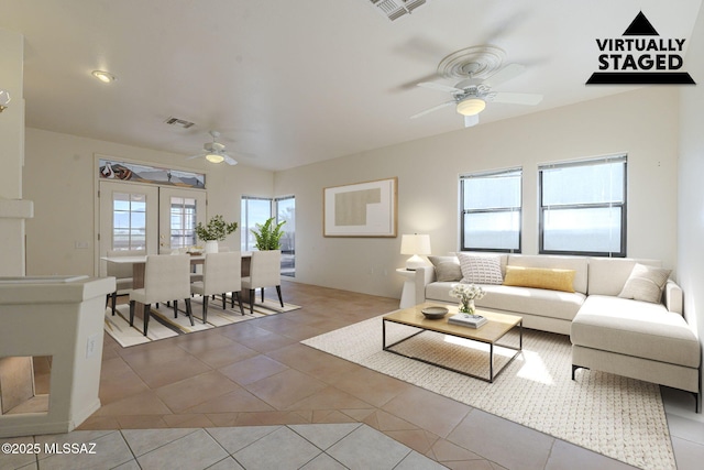 living area with light tile patterned floors, ceiling fan, and visible vents