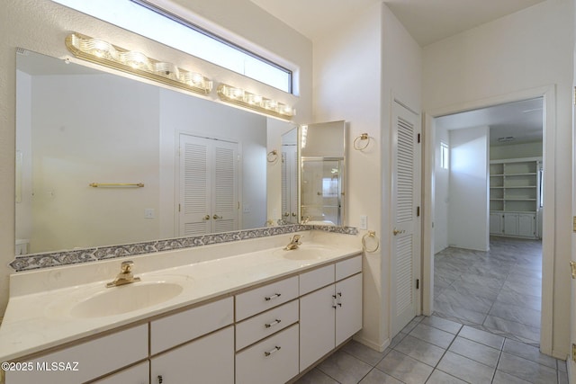 full bathroom featuring a closet, a sink, and double vanity