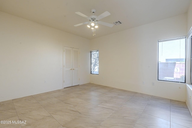 spare room featuring visible vents and a ceiling fan