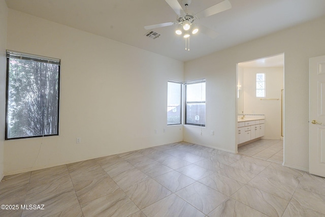 unfurnished bedroom featuring ensuite bath and visible vents