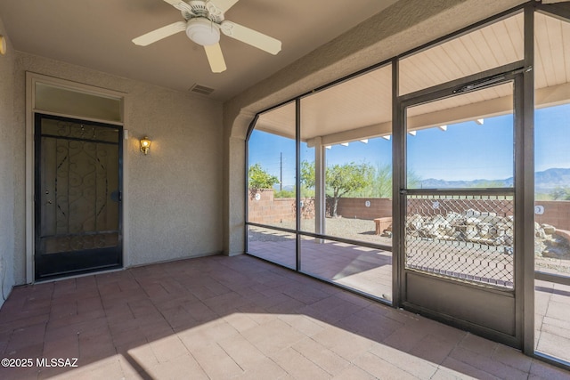 unfurnished sunroom with ceiling fan and visible vents