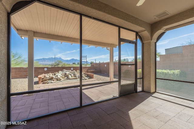 unfurnished sunroom featuring a mountain view and visible vents