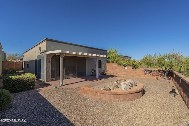 rear view of property with a fenced backyard, a patio, and stucco siding