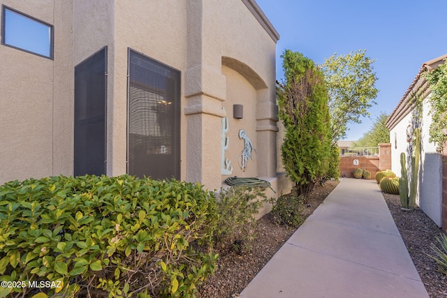 view of property exterior with fence and stucco siding