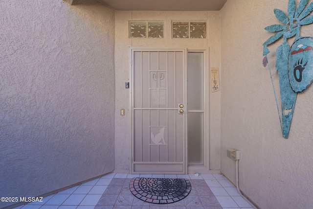 entrance to property featuring stucco siding