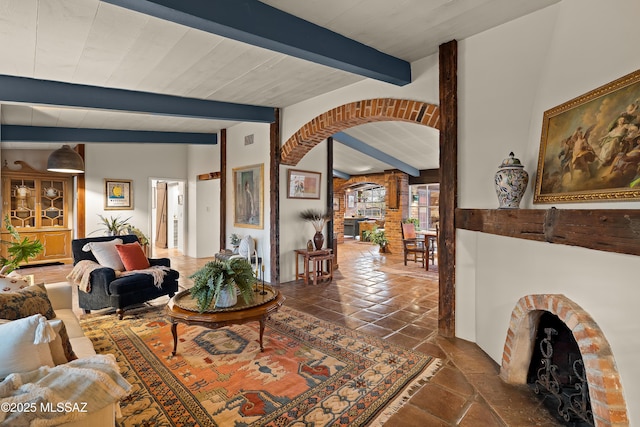 living room featuring vaulted ceiling with beams, visible vents, and arched walkways