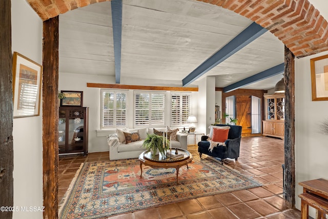 living room featuring beamed ceiling and tile patterned flooring