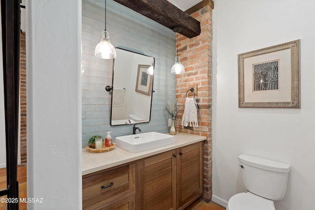 bathroom with toilet, decorative backsplash, and vanity