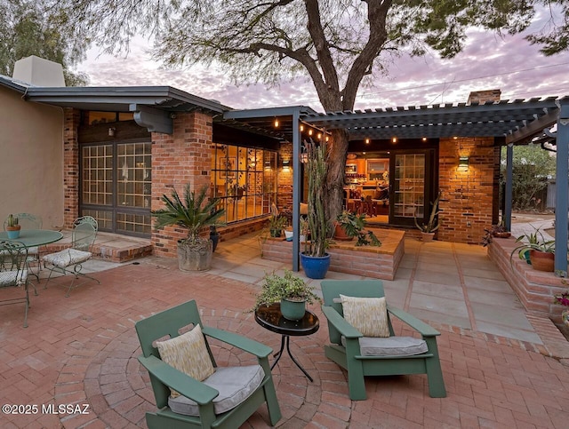 patio terrace at dusk featuring outdoor dining space and a pergola