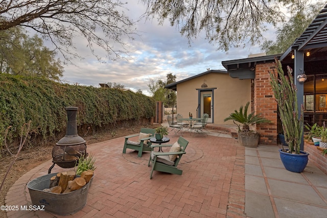 view of patio featuring fence, a fire pit, and outdoor dining space