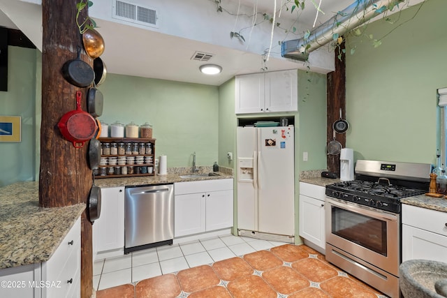 kitchen with white cabinets, visible vents, stainless steel appliances, and a sink