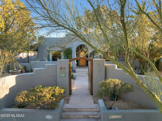 exterior space with a fenced front yard and a gate