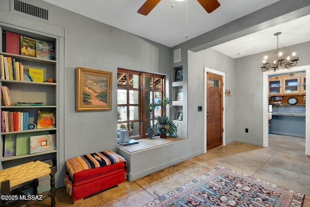 tiled foyer with ceiling fan with notable chandelier, visible vents, and baseboards