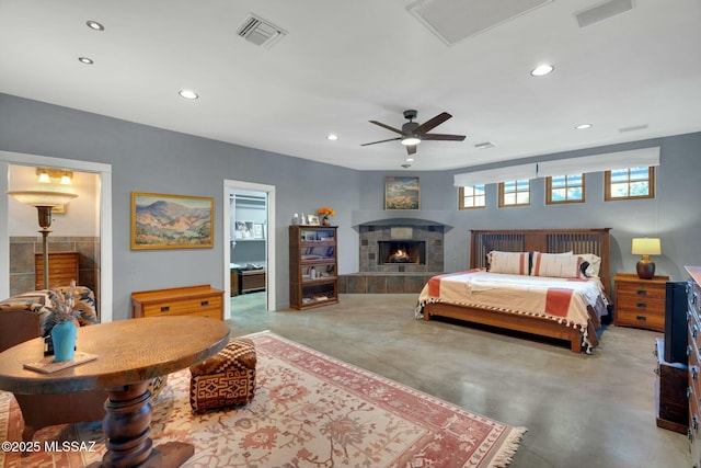 bedroom with concrete floors, visible vents, a tiled fireplace, and recessed lighting