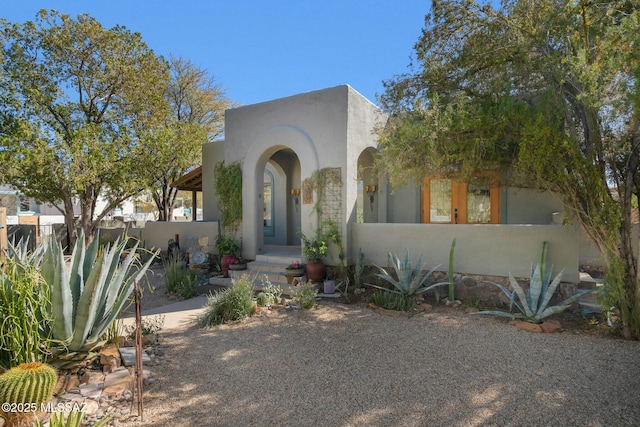 view of front of house with fence and stucco siding